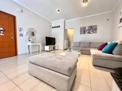 a large living room with a couch and a tv at Central apartment in quiet neighborhood near sandy beach in Chania Town