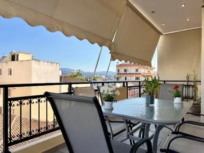 a table and chairs on a balcony with a view at Central apartment in quiet neighborhood near sandy beach in Chania Town