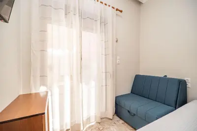 a blue chair in a room with a window at Casa Armonia Seaside by 8essentially in Chania Town