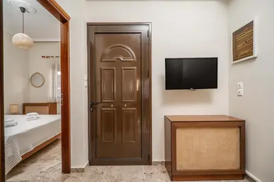 a room with a door with a television and a bed at Casa Armonia Seaside by 8essentially in Chania Town