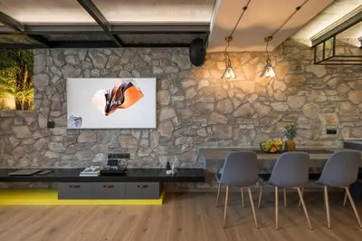 a stone wall in a room with a table and chairs at Skins Concept Boutique Apartment in Chania Town