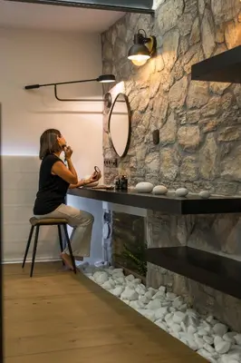 a woman sitting on a chair at a vanity with a mirror at Skins Concept Boutique Apartment in Chania Town