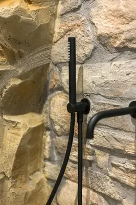 a shower hose hooked up to a stone wall at Skins Concept Boutique Apartment in Chania Town
