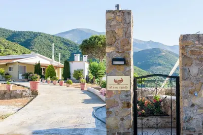 a gate to a villa with mountains in the background at Ktima Abella ✩ Organic Garden ✩ Absolute Privacy in Élos