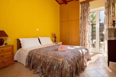 a yellow bedroom with a bed and a window at Ktima Abella ✩ Organic Garden ✩ Absolute Privacy in Élos
