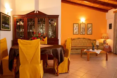a dining room with a table and a cabinet with wine glasses at Ktima Abella ✩ Organic Garden ✩ Absolute Privacy in Élos