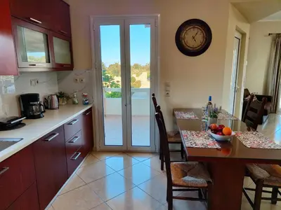a kitchen with a table and a clock on the wall at Pazinos/Neveli Cottage in Galangádhos