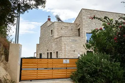 a brick building with a wooden bench in front of it at Villa Olive Valley in Loutrákion