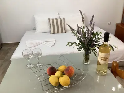 a table with a plate of fruit and a bottle of wine at Landro House in Kissamos