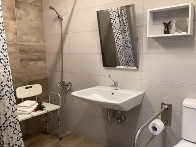 a bathroom with a sink and a toilet and a mirror at Landro House in Kissamos
