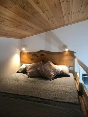 a bed with a wooden headboard and pillows on it at Summer mood in Chania Town