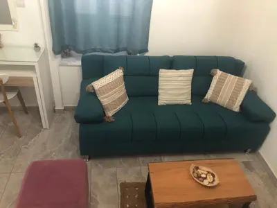 a green couch in a living room with a table at Summer mood in Chania Town
