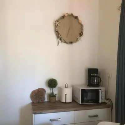 a microwave sitting on top of a wooden cabinet at Summer mood in Chania Town