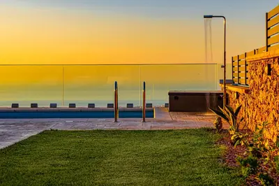 a building with a view of the ocean at sunset at Villa Nektar with private ecologic pool and amazing view! in Kondópoula