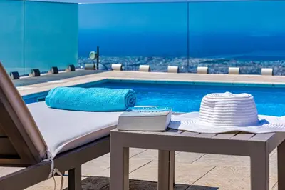 a pool with a bed and a hat on a table at Villa Nektar with private ecologic pool and amazing view! in Kondópoula