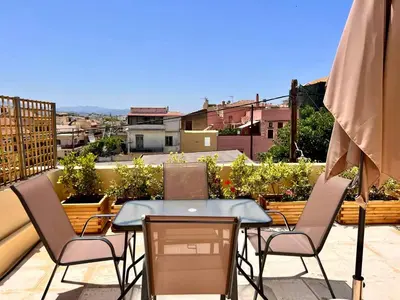 a patio with a table and chairs on a balcony at Canevaro Twins (North) in Chania Town
