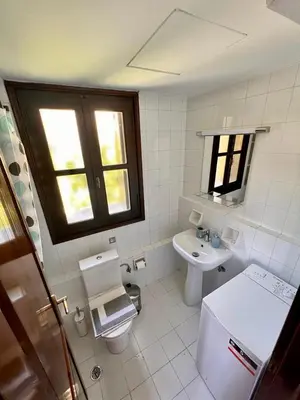 a white bathroom with a sink and a toilet at Canevaro Twins (North) in Chania Town