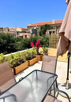 a table and chairs on a balcony with plants at Canevaro Twins (North) in Chania Town