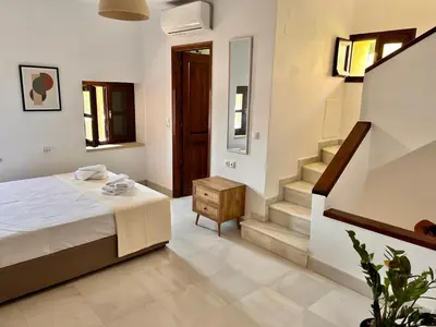 a bedroom with a bed and a staircase in it at Canevaro Twins (North) in Chania Town