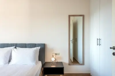 a bedroom with a bed with a mirror and a table at Efrossini Suites in Kounoupidhianá