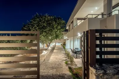 a fence in front of a house at night at Efrossini Suites in Kounoupidhianá