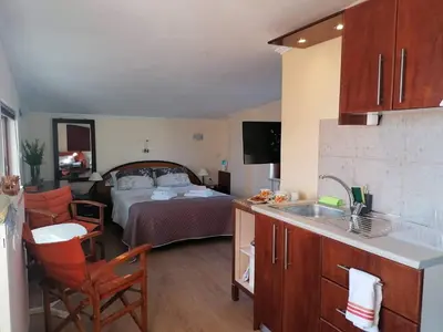 a room with a kitchen and a bedroom with a bed at Casa Ag.Apo in Daratso