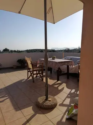 a patio with a table and an umbrella at Casa Ag.Apo in Daratso