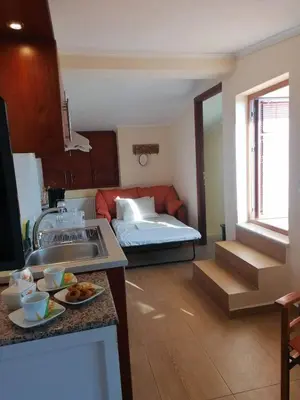 a kitchen with a sink and a room with a bed at Casa Ag.Apo in Daratso