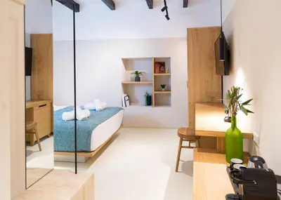 a bedroom with a bed and a desk and a mirror at Incentra in Chania Town