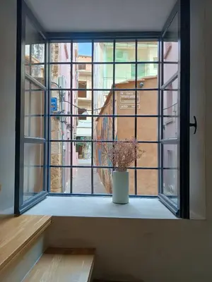 a window with a potted plant sitting on a window sill at Incentra in Chania Town