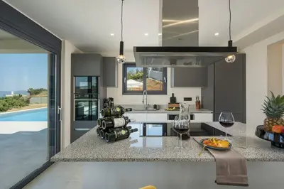 a kitchen with a counter with two glasses of wine at Villa Thea, stunning view, pool, BBQ, Brand new. in Kissamos