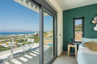 a bedroom with a bed and a balcony with a view at Villa Thea, stunning view, pool, BBQ, Brand new. in Kissamos