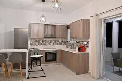 a kitchen with wooden cabinets and a table and chairs at Artemis No1 Apartment in Kissamos