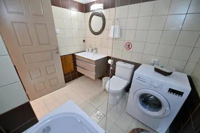 a bathroom with a toilet and a washing machine at Artemis No1 Apartment in Kissamos
