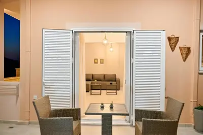 a living room with a couch and a table and chairs at Artemis No1 Apartment in Kissamos