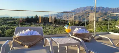 a balcony with two chairs and a table with a drink at Splendid Villas and Family Resort in Kalamitsi Amygdali