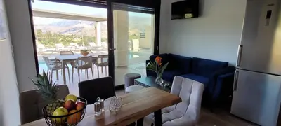 a kitchen and dining room with a table and a refrigerator at Splendid Villas and Family Resort in Kalamitsi Amygdali