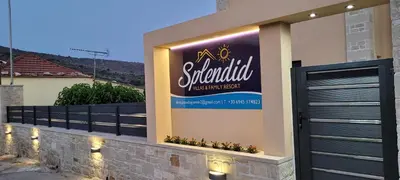 a sign on the side of a house with a garage at Splendid Villas and Family Resort in Kalamitsi Amygdali