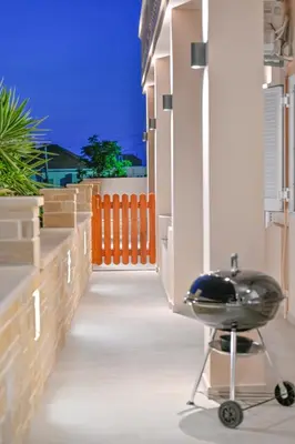 a black chair sitting on the side of a house at Artemis No.2 Apartment in Kissamos