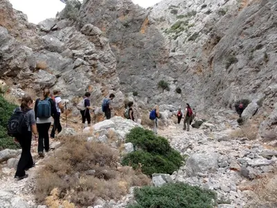 a group of people walking through a rocky mountain at Hippie City Hostel in Chania Town