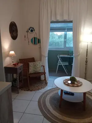 a living room with a table and a chair at Kaldora Apartment in Chania Town