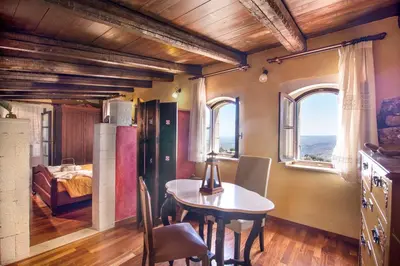 a dining room with a table and a bedroom at Samonas - Red villa Fliskouni in Chania Town