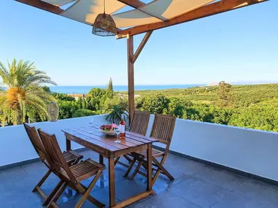 a table and chairs on a balcony with a view of the ocean at Remvi Suite in Chania in Xamoudhokhórion