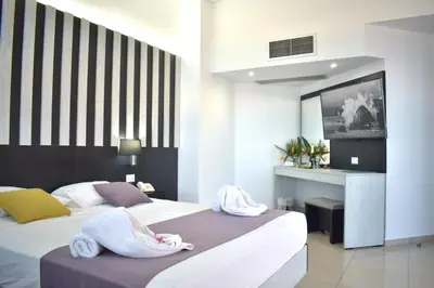 a hotel room with two beds with towels on them at Galini Sea View Hotel in Agia Marina Nea Kydonias