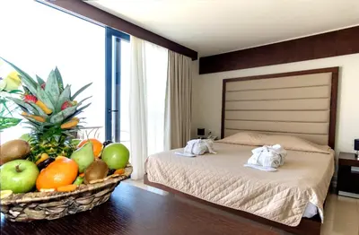 a bedroom with a bed and a basket of fruit at Galini Sea View Hotel in Agia Marina Nea Kydonias