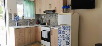 a kitchen with a stove and a refrigerator at Shiny Luxe :) in Kissamos