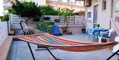 a hammock on a patio with a table and chairs at Shiny Luxe :) in Kissamos