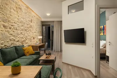 a living room with a green couch and a stone wall at Dimitra Central Apts in Chania Town