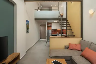 a living room with a couch and a kitchen in the distance at Dimitra Central Apts in Chania Town