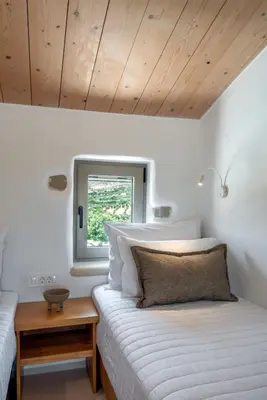 a bedroom with a white bed and a window at Villa Froudi in Kissamos